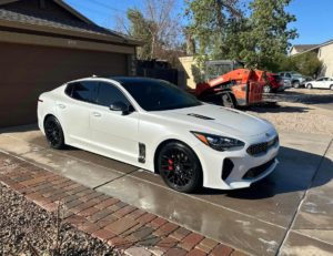 a white Kia sedan looking shiny after an exterior detailing session