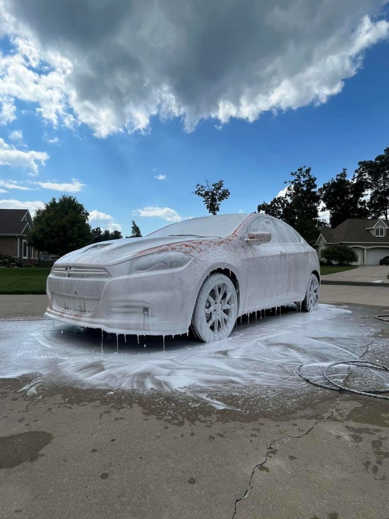 a sedan covered in soapy water in preparation for our mobile car wash service