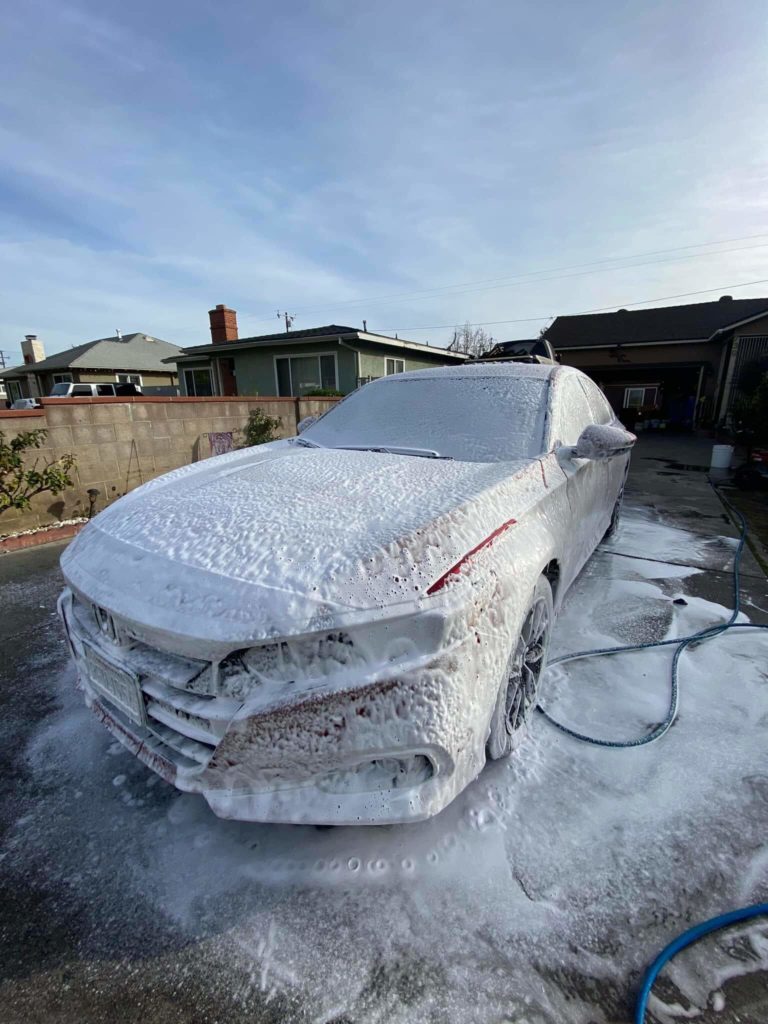 a Honda Civic foamed up with soapy water in preparation for a hand wash