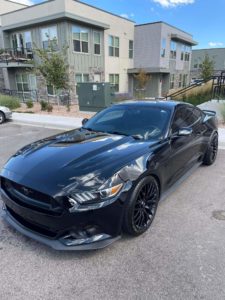 a clean black mustang parked on a street