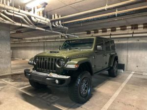 a green jeep in a parking spot after getting hand washed