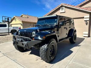 a jeep that has been washed in a driveway using our mobile car cleaning services