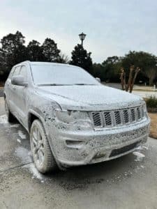 a Jeep Cherokee covered in soapy white foam