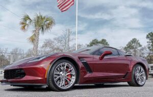 a red car parked outside with a palm tree in the background