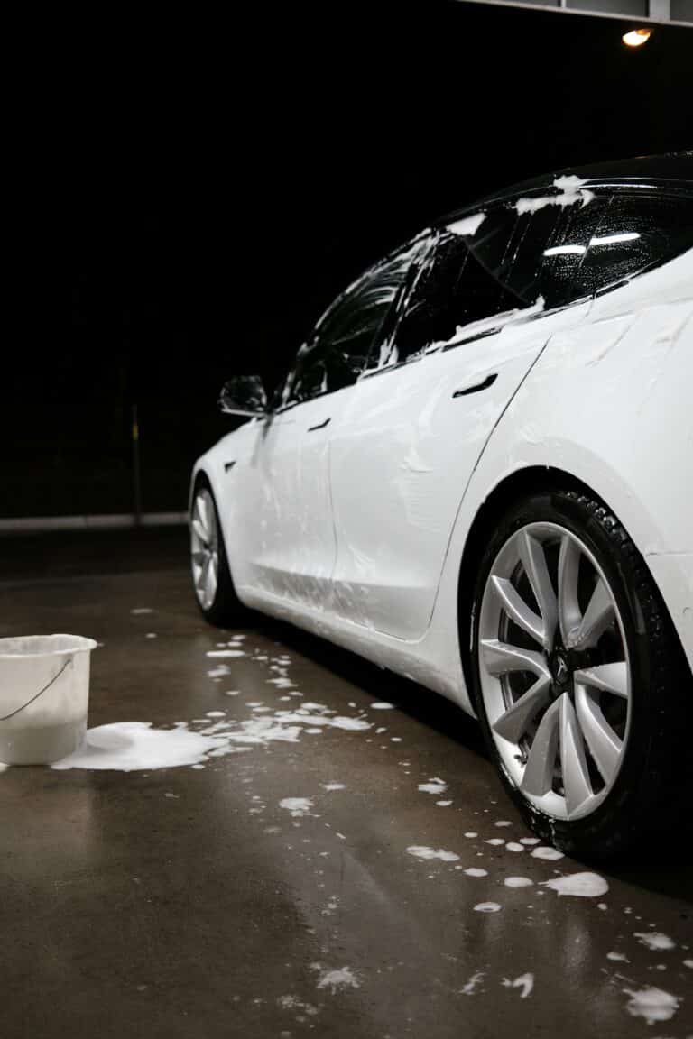 a whiter tesla sedan receiving an exterior detail