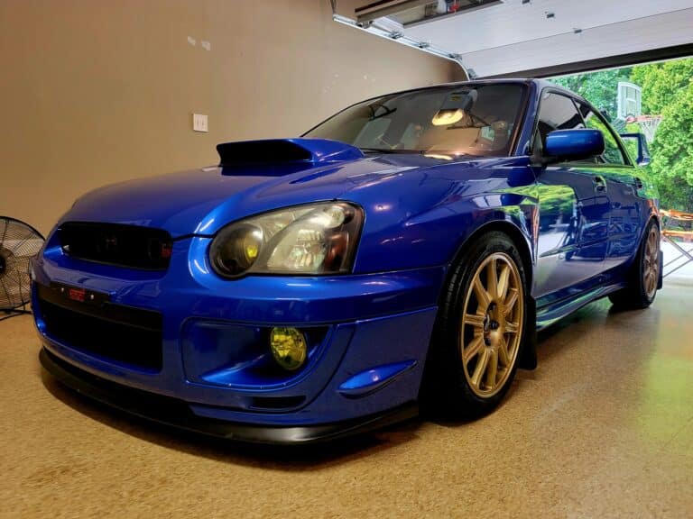 A blue Subaru STI sports car parked in a customers garage after being cleaned inside and out