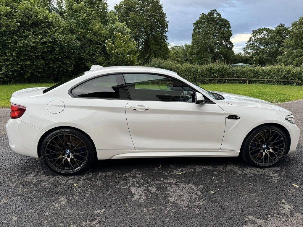 White BMW coupe parked at the customer's home after receiving our wash and wax service.